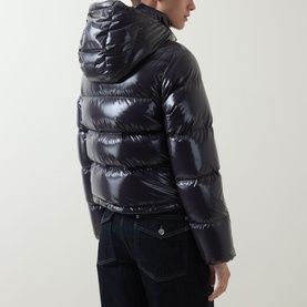 Model wearing Moncler Niveole Glossy Down Jacket in navy, boudin quilted with detachable hood, shown from rear three-quarter angle