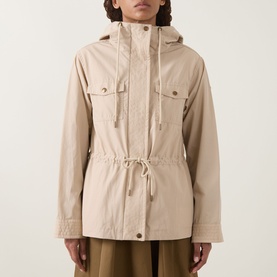 Model wearing Moncler beige hooded jacket with drawstring waist, chest pockets and toggle detail, styled with olive wide-leg trousers