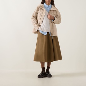Model wearing Moncler beige jacket with blue shirt, khaki midi skirt and black chunky loafers.