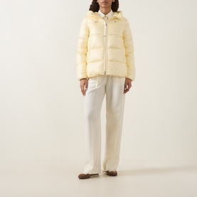 Model wearing Moncler light yellow hooded puffer jacket with zip fastening, styled with white wide-leg trousers