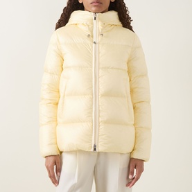 Model wearing Moncler light yellow hooded puffer jacket with zip fastening, styled with white trousers