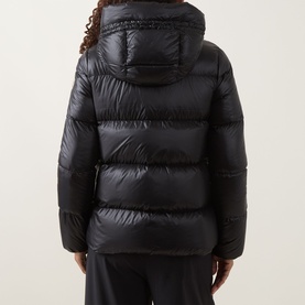 Model wearing Moncler black quilted hooded down jacket, rear view, styled with black trousers