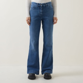 Model wearing Moncler medium blue wide-leg flared jeans in cotton, styled with a grey long-sleeve top and black shoes.