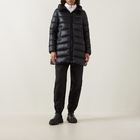 Model wearing Moncler black quilted down parka with hood, styled with black joggers and chunky black boots