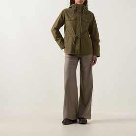 Model wearing Moncler olive parka with hood, drawstring waist and chest pockets, styled with wide-leg taupe trousers