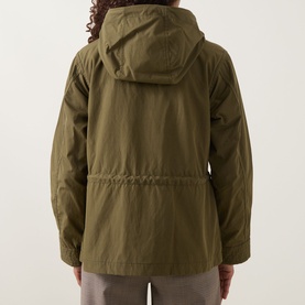 Model wearing Moncler olive parka, back view showing hood, drawstring waist, and polyester-cotton fabric.