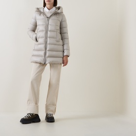 Model wearing Moncler cream polyamide parka with hood, styled with cream trousers and black chunky trainers.
