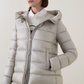 Model wearing Moncler cream parka with hood, quilted panelling and asymmetric zip, styled with white collared top underneath