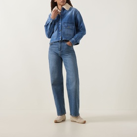 Model wearing Moncler medium blue cotton shirt with chest pockets and shearling collar, styled with matching blue straight-leg jeans and cream