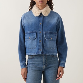 Model wearing Moncler medium blue denim jacket with cream shearling collar, button front, and twin chest pockets, styled with blue jeans