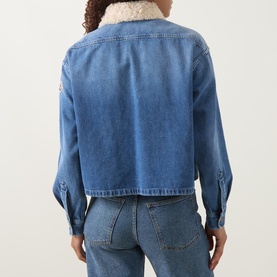 Model wearing Moncler medium blue denim cropped shirt with sherpa collar, rear view, styled with light blue jeans.