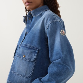Model wearing Moncler medium blue denim shirt with chest patch pocket and logo arm badge, cropped relaxed fit