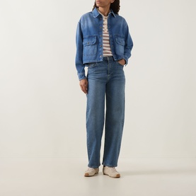 Model wearing Moncler medium blue cotton shirt jacket with chest pockets, styled with stripe top, wide-leg jeans and cream trainers