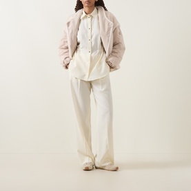 Model wearing Moncler cream wool and polyamide shirt with blush quilted jacket and wide-leg cream trousers