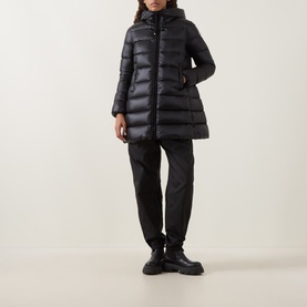 Model wearing Moncler black quilted down parka with hood, styled with black trousers and chunky black boots