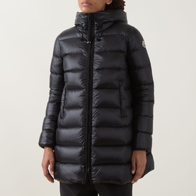 Model wearing Moncler black quilted down parka with hood, zip fastening, and knee-length silhouette