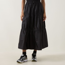 Model wearing Moncler black tiered midi skirt in polyamide, styled with black and white chunky trainers