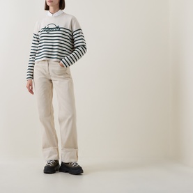 Model wearing Moncler lime striped wool sweat with script logo, styled with cream wide-leg trousers and black chunky trainers
