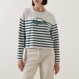 Model wearing Moncler striped wool sweatshirt in lime, featuring contrast logo lettering, crew neck, paired with cream trousers.