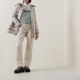 Model wearing Moncler lime wool sweatshirt with navy stripe detail, styled with grey puffer jacket and cream wide-leg trousers.