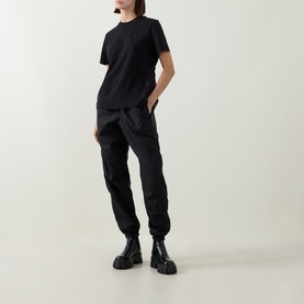Model wearing Moncler black cotton T-shirt with black cargo trousers and chunky black ankle boots.