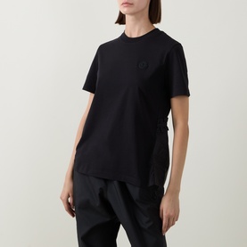 Model wearing Moncler black cotton T-shirt with tonal logo patch, styled with black wide-leg trousers