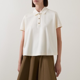 Model wearing Moncler cream cotton polo top with short sleeves, collared neckline and gold-tone button placket, styled with olive wide-leg skirt