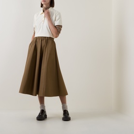 Model wearing Moncler cream cotton top, styled with olive midi skirt, grey socks and black chunky loafers