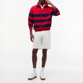 Model wearing Tommy Hilfiger medium red and navy bold stripe rugby polo shirt, styled with white shorts and white trainers