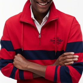 Model wearing Tommy Hilfiger Medium Red quarter-zip sweatshirt with navy block stripes and embroidered logo, styled over white collar shirt