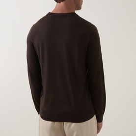 Model wearing Paul Smith brown merino wool crew neck jumper, back view, styled with cream trousers.