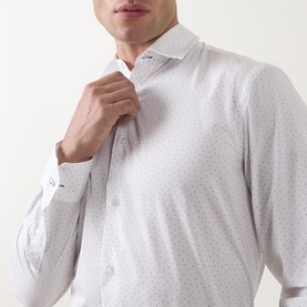 Model wearing Paul Smith white slim fit formal shirt with fine dot print, single cuff, adjusting collar. 100% cotton.