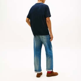 Model wearing navy crew neck T-shirt, styled with light wash straight-leg jeans and brown suede shoes, rear view