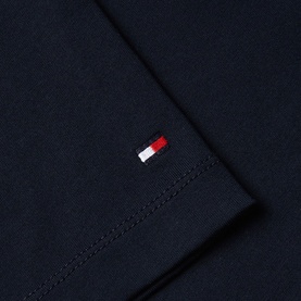 Tommy Hilfiger navy cotton fabric close-up showing embroidered flag logo detail on sleeve hem