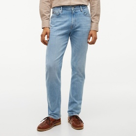 Model wearing Tommy Hilfiger Rio Blue straight-leg jeans, styled with a checked shirt and brown leather boat shoes.
