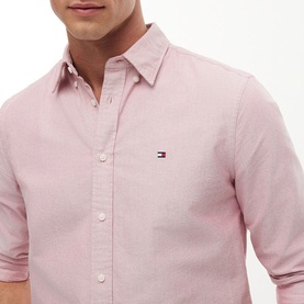 Model wearing Tommy Hilfiger medium red long-sleeve shirt with button-down collar and embroidered flag logo