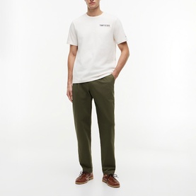 Model wearing Tommy Hilfiger Ivory Petal T-shirt with small chest logo, styled with olive green chinos and brown leather shoes