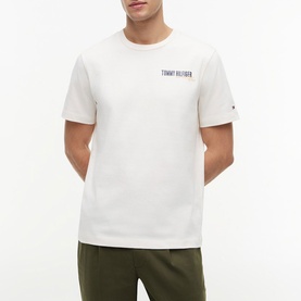 Model wearing Tommy Hilfiger Ivory Petal crew neck T-shirt with small chest logo, styled with khaki joggers.
