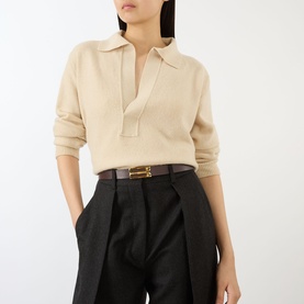 Model with Victoria Beckham Dorian Frame Leather Belt in Dark Burgundy, gold B-frame hardware, styled with cream knit polo and black tailored