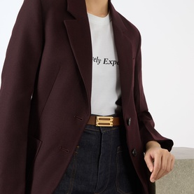 Model with Victoria Beckham Dorian Frame Leather Belt in Dark Tan, gold-plated B-frame buckle, worn over white tee and dark jeans with burgundy