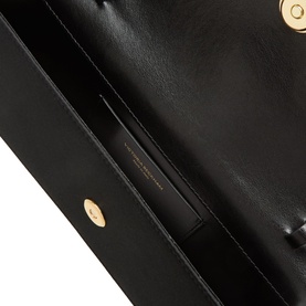 Victoria Beckham black clutch bag interior view, smooth lining with gold-tone press-stud fastening detail visible
