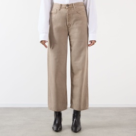 Model wearing AgoldE Wide Leg Jeans in Trail, a warm beige tone, styled with a white top and black ankle boots.