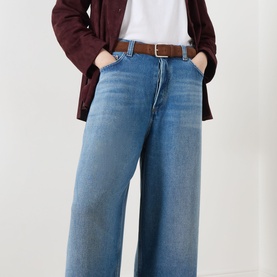 Model wearing AgoldE Rounded Baggy Wide-Leg Jeans in Expression mid wash, styled with a brown belt, white tee and burgundy overshirt.