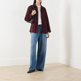 Model wearing AgolDe Rounded Baggy Wide-Leg Jeans in Expression, mid-wash, styled with a burgundy jacket, white top and black loafers.