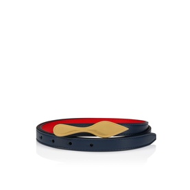 Christian Louboutin ladies belt in navy leather with gold-tone buckle and red interior lining, shown coiled flat.