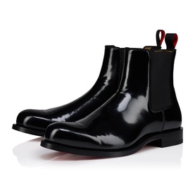 Christian Louboutin black polished leather Chelsea boots with elastic side panels, signature red lining, and flat rubber sole