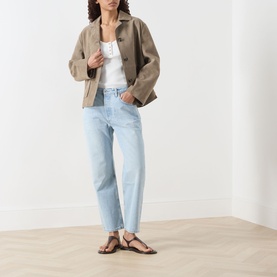 Model wearing Citizens of Humanity Winslow Boyfriend Jeans in Horizon light wash, styled with a tan jacket, white top and brown sandals.