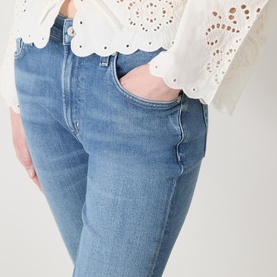 Model wearing Citizens of Humanity Goldie Ankle Kick Flare Jeans in Calla, light blue denim with whiskering detail, styled with white broderie top
