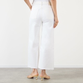Model wearing Citizens of Humanity Lyra High-Rise Cropped Wide Leg Jeans in Soft White with frayed hem, styled with gold strappy heels.
