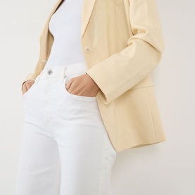 Model wearing Citizens of Humanity Lyra High-Rise Cropped Wide Leg Jeans in Soft White, styled with a cream blazer and white top.